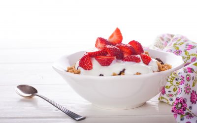Yogurt with homemade granola or muesli and fresh strawberries for healthy morning breakfast, selective focus, over white. Healthy food background with copy space for text.
